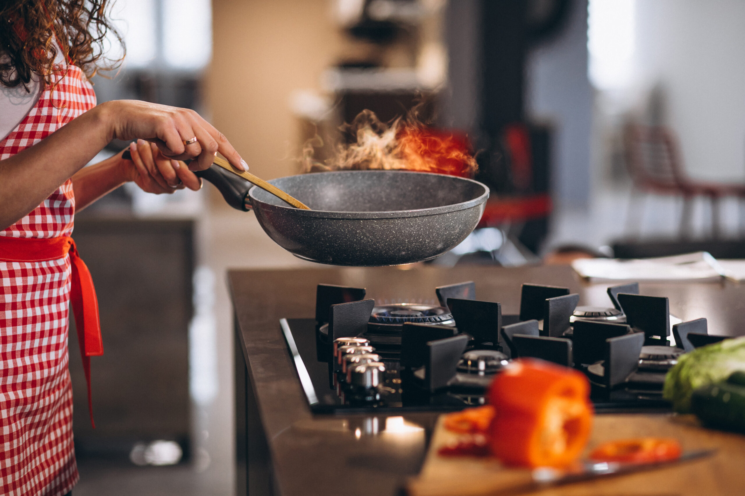 Woman chef cooking vegetables in pan